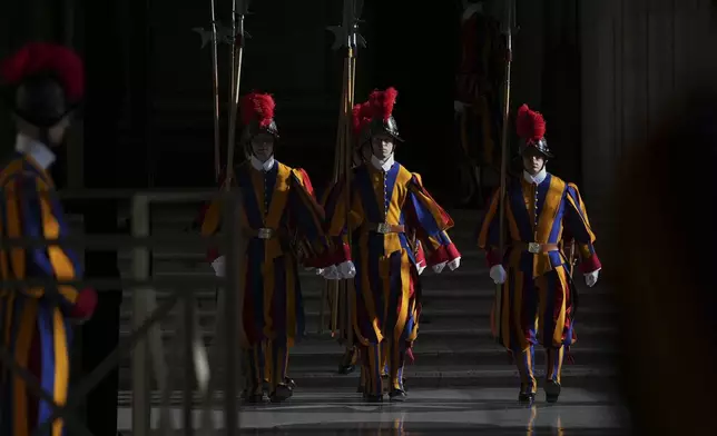 Vatican Swiss Guards stand in the atrium of St. Peter's Basilica at the Vatican before the body of Pope Francis will be carried inside where he will lie in state for three days, Wednesday, April 23, 2025. (AP Photo/Andrew Medichini, Pool)