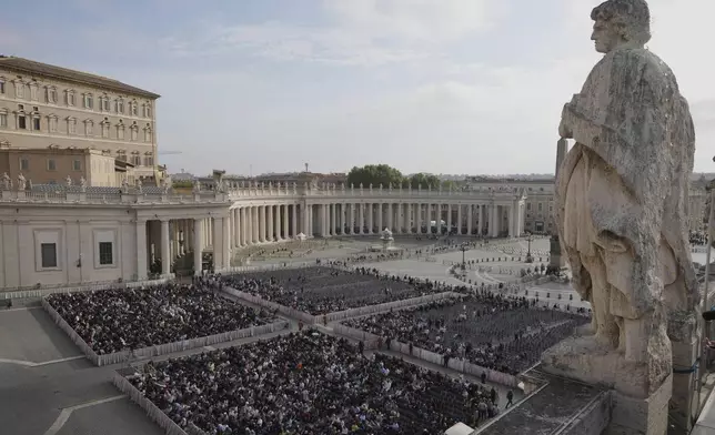 People gather in St. Peter's Square as they await the arrival of the body of Pope Francis, who will lie in state at St. Peter's Basilica for three days, at the Vatican, Wednesday, April 23, 2025. (AP Photo/Markus Schreiber)
