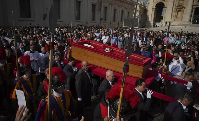 The body of Pope Francis is carried into St. Peter's Basilica at the Vatican, Wednesday, April 23, 2025, where he will lie in state for three days. (AP Photo/Emilio Morenatti)