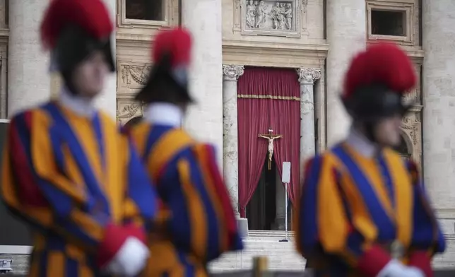 Vatican Swiss Guards frame the entrance of St. Peter's Basilica where the body of Pope Francis will lie in state for three days, at the Vatican, Wednesday, April 23, 2025. (AP Photo/Andrew Medichini)