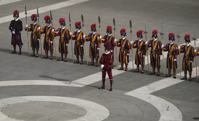 Swiss guards stand in St. Peter's Square as they await the arrival of the body of Pope Francis, who will lie in state at St. Peter's Basilica for three days, at the Vatican, Wednesday, April 23, 2025. (AP Photo/Markus Schreiber)
