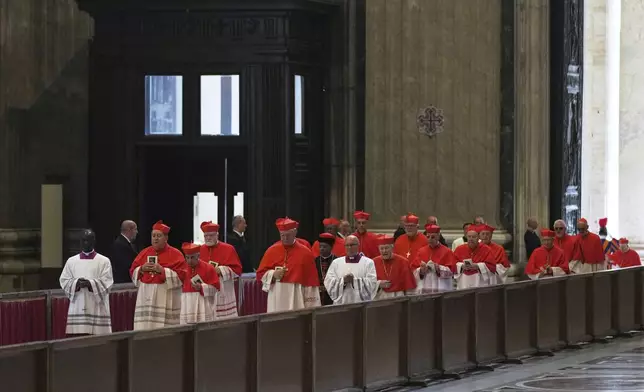 Cardinal's in the procession with the body of Pope Francis, who will lie in state for three days, enter St. Peter's Basilica at the Vatican, Wednesday, April 23, 2025. (AP Photo/Francisco Seco)