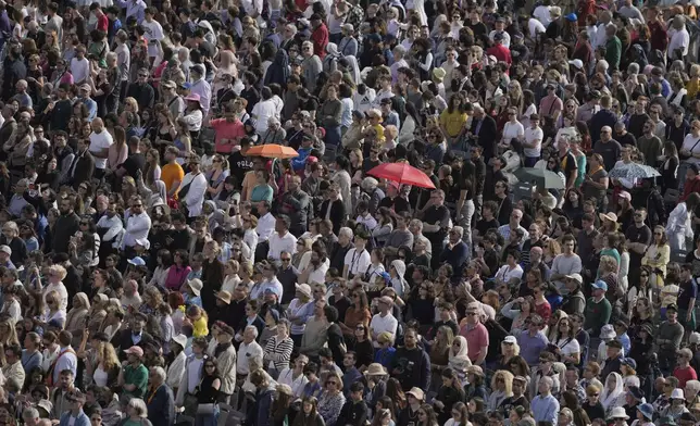 People gather in St. Peter's Square as they await the arrival of the body of Pope Francis, who will lie in state at St. Peter's Basilica for three days, at the Vatican, Wednesday, April 23, 2025. (AP Photo/Markus Schreiber)