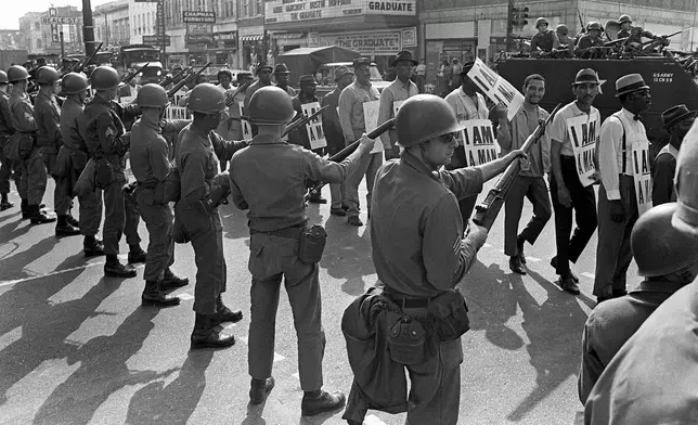 FILE - Striking sanitation workers and their supporters are flanked by bayonet-wielding National Guard troops and armored vehicles, during a march on City Hall in Memphis, Tenn., March 29, 1968, one day after a similar march erupted in violence, leaving one person dead and several injured. (AP Photo/Charlie Kelly, File)