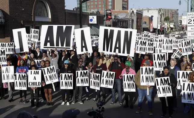 FILE - People hold signs resembling the signs carried by striking sanitation workers in 1968 as they join in events commemorating the 50th anniversary of the assassination of the Rev. Martin Luther King Jr. on Wednesday, April 4, 2018, in Memphis, Tenn. King was assassinated April 4, 1968, while in Memphis supporting striking sanitation workers. (AP Photo/Mark Humphrey, File)
