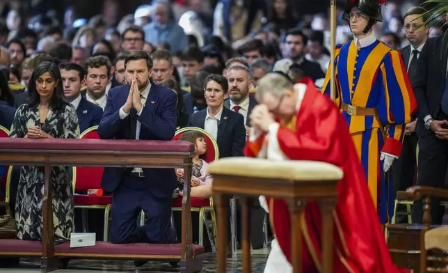 U.S. Vice President JD Vance, and his wife Usha Vance, left, with their daughter Mirabel, attend a Good Friday service led by Cardinal Claudio Gugerotti, right, inside St. Peter's Basilica at the Vatican, Friday, April 18, 2025. (AP Photo/Alessandra Tarantino)