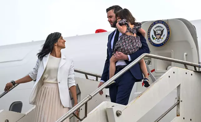 Second Lady Usha Vance looks back at U.S. Vice President JD Vance, carrying their daughter Mirabel as they disembark Air Force Two upon arriving at G.B. Pastine–Rome Ciampino Airport, Friday April 18, 2025. (Kenny Holston/The New York Times via AP, Pool)