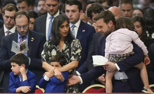 U.S. Vice President JD Vance, and his wife Usha Vance, with their daughter Mirabel, back to camera, and sons Vivek and Ewan, left, attend a Good Friday service inside St. Peter's Basilica at the Vatican, Friday, April 18, 2025. (AP Photo/Alessandra Tarantino)