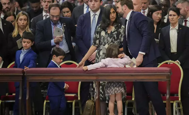 U.S. Vice President JD Vance, and his wife Usha Vance, with their daughter Mirabel, back to camera, and sons Vivek and Ewan, left, attend a Good Friday service inside St. Peter's Basilica at the Vatican, Friday, April 18, 2025. (AP Photo/Alessandra Tarantino)