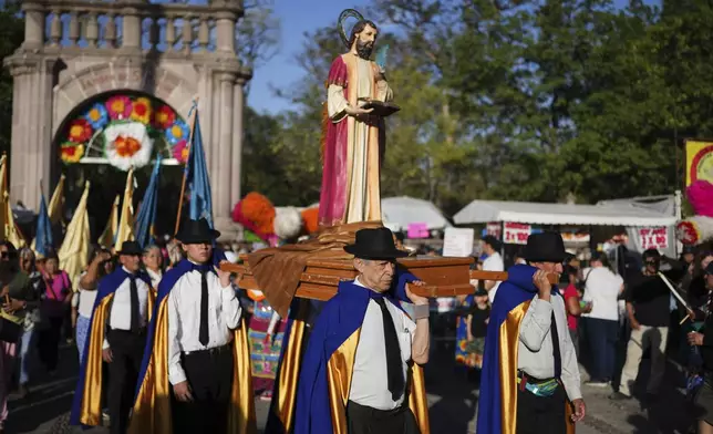 Parishioners carry a religious float with a statue of St. Mark during a month-long event honoring the saint, outside St. Mark's church in Aguascalientes, Mexico, Friday, April 25, 2025. (AP Photo/Eduardo Verdugo)
