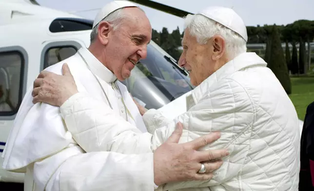 FILE - Pope Francis, left, meets Pope emeritus Benedict XVI in Castel Gandolfo, Italy, on Saturday, March 23, 2013. Emeritus Pope Benedict XVI has emerged from his self-imposed silence inside the Vatican to publish a lengthy letter to one of Italy's most well-known atheists. In it, he defends his record on handling sexually abusive priests and discusses everything from evolution to theology to the figure of Jesus Christ. Excerpts of the letter were published Tuesday, Sept. 24, 2013 by La Repubblica, the same newspaper which just two weeks ago published a similar letter from Pope Francis to its own atheist publisher. The letters indicate the two men in white, who live across the Vatican gardens from one another, are pursuing a collaborative campaign of sorts to engage non-believers. (AP Photo/Pool Photo via AP, file)