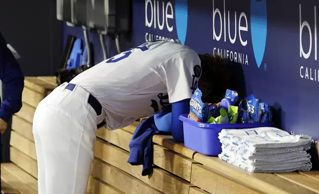 Los Angeles Dodgers' Dustin May hangs his head in the dugout after striking out the side against the Atlanta Braves during the first inning of a baseball game Tuesday, April 1, 2025, in Los Angeles. (AP Photo/Kevork Djansezian)