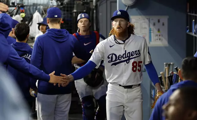 Los Angeles Dodgers' Dustin May is congratulated in the dugout after striking out the side against the Atlanta Braves during the first inning of a baseball game Tuesday, April 1, 2025, in Los Angeles. (AP Photo/Kevork Djansezian)