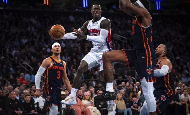 Detroit Pistons guard Dennis Schroder, center, leaps to pass the ball during the second half of Game 2 of an NBA basketball first-round playoff series against the New York Knicks, Monday, April 21, 2025, in New York. (AP Photo/Angelina Katsanis)