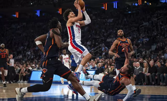 Detroit Pistons guard Cade Cunningham (2) scores and knocks down New York Knicks guard Jalen Brunson (11) during the first half of Game 2 of an NBA basketball first-round playoff series, Monday, April 21, 2025, in New York. (AP Photo/Angelina Katsanis)