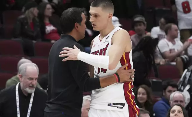 Miami Heat guard Tyler Herro, right, hugs head coach Erik Spoelstra during the second half of an NBA play-in tournament basketball game against the Chicago Bulls in Chicago, Wednesday, April 16, 2025. (AP Photo/Nam Y. Huh)