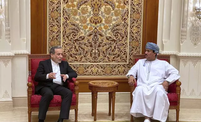 In this photo released by Iranian Foreign Ministry, Iranian Foreign Minister Abbas Araghchi, left, speaks with an unidentified Omani official upon his arrival at Muscat, Oman, Friday, April 25, 2025, a day prior to negotiations with U.S. Mideast envoy Steve Witkoff. (Iranian Foreign Ministry via AP)