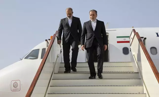 In this photo released by Iranian Foreign Ministry, Iranian Foreign Minister Abbas Araghchi, right, steps out from his plane as he arrives at Muscat, Oman, Friday, April 25, 2025, a day prior to negotiations with U.S. Mideast envoy Steve Witkoff. (Iranian Foreign Ministry via AP)