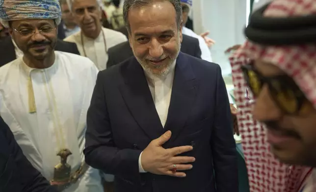Iranian Foreign Minister Abbas Araghchi, center, and Omani Foreign Minister Badr al-Busaidi, left, walk through the Muscat International Book Fair in Oman, Friday, April 25, 2025. (AP Photo/Fatima Shbair)