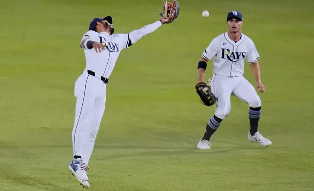 Tampa Bay Rays right fielder Jose Caballero, left, misplays a double by Boston Red Sox's Jarren Duran during the fifth inning of a baseball game Wednesday, April 16, 2025, in Tampa, Fla. Looking on is centerfielder Jake Mangum. (AP Photo/Chris O'Meara)