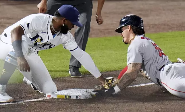 Tampa Bay Rays third base Junior Caminero, left, tags out Boston Red Sox's Jarren Duran while attempting to steals third base during the fifth inning of a baseball game Wednesday, April 16, 2025, in Tampa, Fla. (AP Photo/Chris O'Meara)
