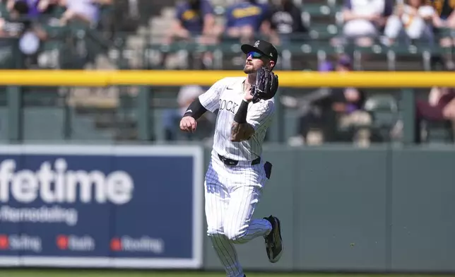 Colorado Rockies center fielder Brenton Doyle pulls in a fly ball off the bat of Milwaukee Brewers' Joey Ortiz in the third inning of a baseball game Thursday, April 10, 2025, in Denver. (AP Photo/David Zalubowski)