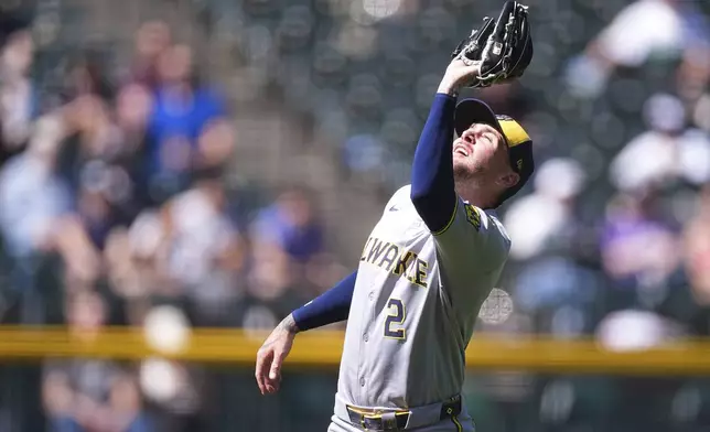 Milwaukee Brewers second baseman Brice Turang pulls in a pop fly off the bat of Colorado Rockies' Kyle Farmer to end the fifth inning of a baseball game Thursday, April 10, 2025, in Denver. (AP Photo/David Zalubowski)