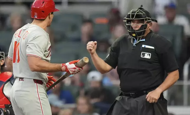 Philadelphia Phillies catcher J.T. Realmuto (10) speaks with the umpire after striking out against the Atlanta Braves in the second inning of a baseball game, Thursday, April 10, 2025, in Atlanta. (AP Photo/Mike Stewart)