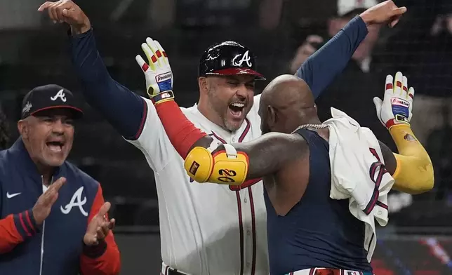Atlanta Braves designated hitter Marcell Ozuna (20) celebrates his walk-off two-run homer against the Philadelphia Phillies in the 11th inning of a baseball game after a rain delay, Friday, April 11, 2025, in Atlanta. (AP Photo/Mike Stewart)