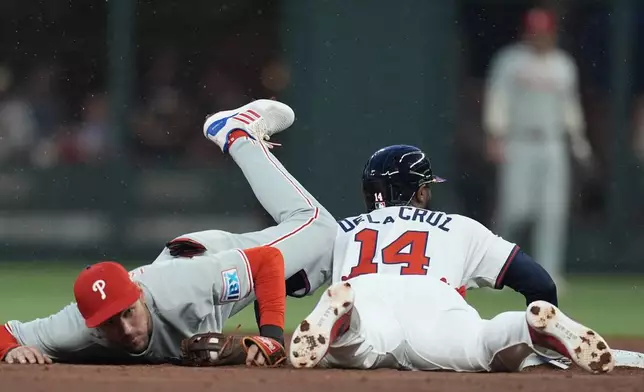 Philadelphia Phillies shortstop Trea Turner (7) tags Atlanta Braves outfield Bryan De La Cruz (14) out at second base in the second inning of a baseball game, Thursday, April 10, 2025, in Atlanta. (AP Photo/Mike Stewart)