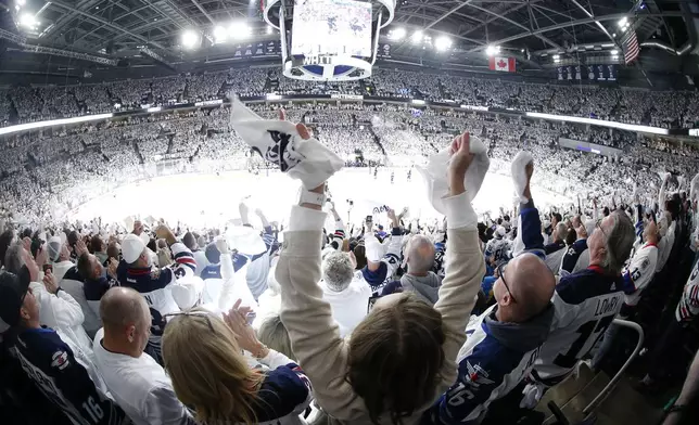 Fans celebrate Winnipeg Jets' Morgan Barron's goal against the St. Louis Blues during first period NHL playoff action in Winnipeg on Saturday, April 19, 2025. (John Woods/The Canadian Press via AP)