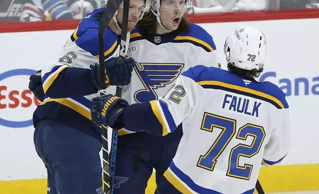 St. Louis Blues' Philip Broberg (6), Oskar Sundqvist (70) and Justin Faulk (72) celebrate after Sundqvist's goal against the Winnipeg Jets during first-period NHL hockey playoff first-round action in Winnipeg, Manitoba, Saturday, April 19, 2025. (John Woods/The Canadian Press via AP)