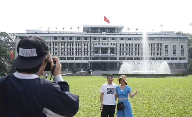Tourists pose for photos in front of Independence Palace in Ho Chi Minh City, Vietnam, Feb. 20, 2025. (AP Photo/Hau Dinh)