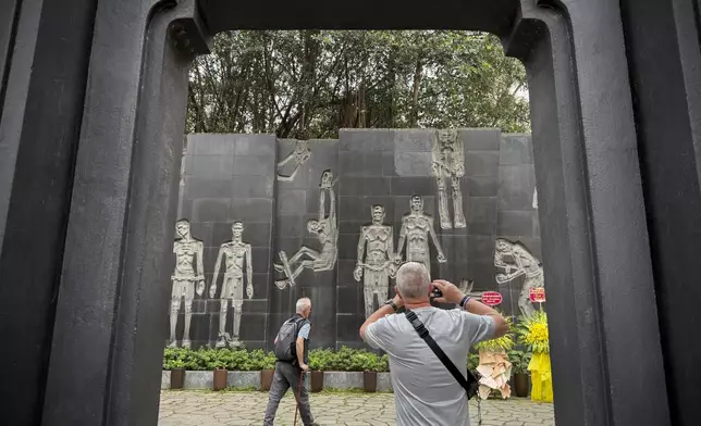 A tourist takes photos of a mural at the Hoa Lo prison museum in Hanoi, Vietnam, March 26, 2025. (AP Photo/Hau Dinh)