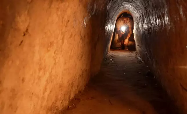 A tourist moves in a narrow tunnel passage in the relic site of Cu Chi tunnels in Ho Chi Minh City, Vietnam, Feb. 23, 2025. (AP Photo/Hau Dinh)