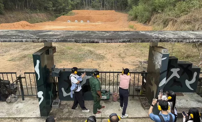 A tourist shoots targets with a war-era weapon at a firing range near Cu Chi tunnels in Ho Chi Minh City, Vietnam, Feb. 23, 2025. (AP Photo/Hau Dinh)
