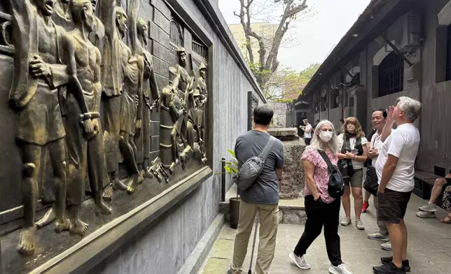 Tourists look at a mural at the Hoa Lo prison museum in Hanoi, Vietnam, March. 26, 2025. (AP Photo/Hau Dinh)