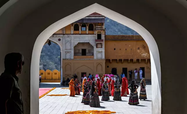 Men and women dressed in traditional attire prepare to do a cultural performance for U.S. Vice President JD Vance and his family at Amber Fort, a historical site, in Jaipur, India, Tuesday, April 22, 2025. (Kenny Holston/The New York Times via AP, Pool)