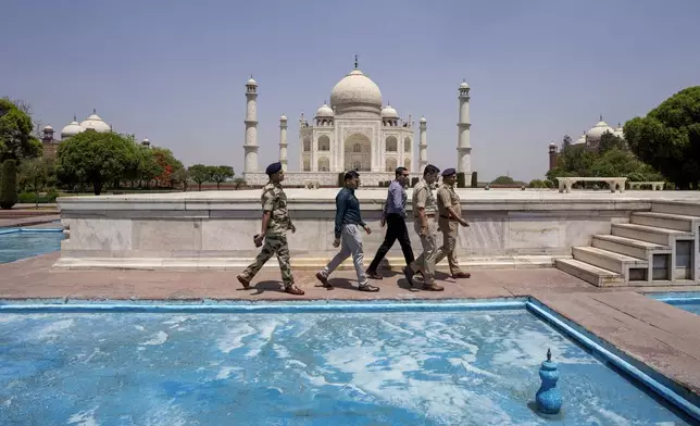 Security officers walk with the Taj Mahal in the background in Agra, India Wednesday, April 23, 2025. (AP Photo/Rajesh Kumar Singh)