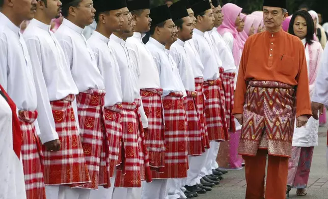 FILE - Malaysia's Prime Minister Abdullah Ahmad Badawi, right, inspects the members of youth wing of United Malays National Organization during the UMNO general meeting in Kuala Lumpur, Malaysia, Thursday, Sept. 23, 2004. (AP Photo/Vincent Thian, File)
