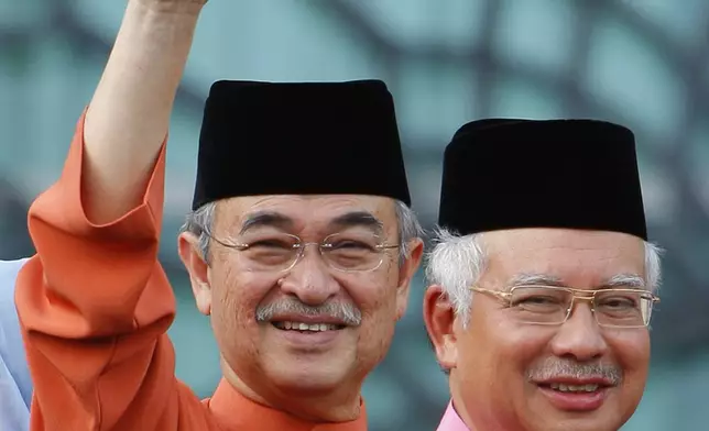 FILE - Malaysia's former Prime Minister Abdullah Ahmad Badawi, left, waves as new Prime Minister Najib Razak smile behind at Prime Minister office in Putrajaya, April 3, 2009. (AP Photo/Vincent Thian, File)
