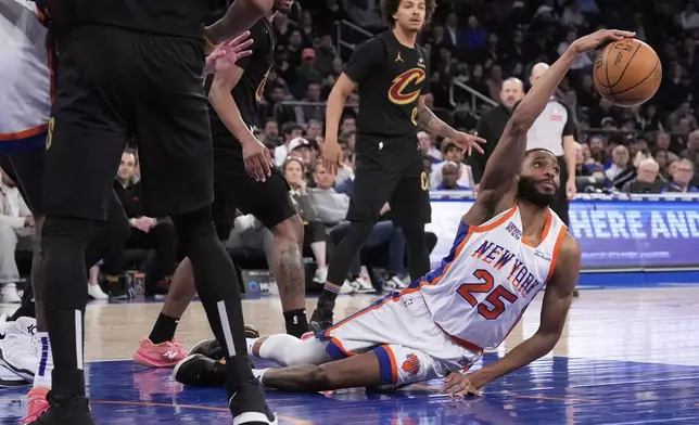 New York Knicks' Mikal Bridges (25) grabs a rebound from the floor during the second half of an NBA basketball game against the Cleveland Cavaliers Friday, April 11, 2025, in New York. (AP Photo/Seth Wenig)