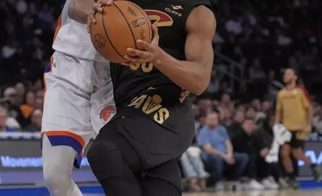 Cleveland Cavaliers' Isaac Okoro, right, drives past New York Knicks' Mitchell Robinson during the first half of an NBA basketball game Friday, April 11, 2025, in New York. (AP Photo/Seth Wenig)
