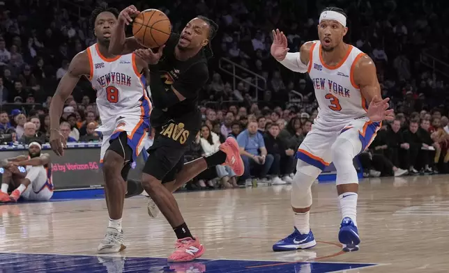 New York Knicks' Josh Hart, right, reacts was he fouls Cleveland Cavaliers' Darius Garland, center, during the first half of an NBA basketball game Friday, April 11, 2025, in New York. (AP Photo/Seth Wenig)