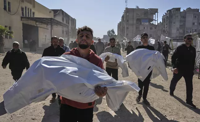 Mourners carry white sacks covering the bodies of members of the Abu Al-Rous family, killed when an Israeli airstrike struck their displacement tent overnight, during their funeral in Khan Younis, southern Gaza Strip, Thursday, April 17, 2025. (AP Photo/Abdel Kareem Hana)