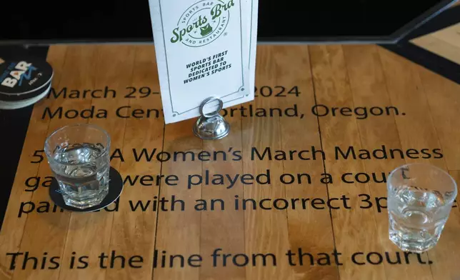 A bar top is seen at The Sports Bra that the sports bar on Friday, April 4, 2025, in Portland, Ore., which was made from the court with the mismatched 3-point lines that caused a stir during the women's tournament games played in Portland in 2024. (AP Photo/Jenny Kane)
