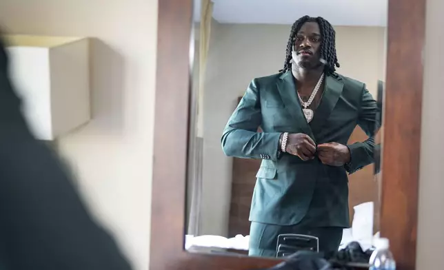 Texas A&amp;M edge rusher Shemar Stewart tries on a suit from designer Baynes + Baker ahead of the NFL Draft, Wednesday, April 23, 2025, in Green Bay, Wis. (AP Photo/Matt Ludtke)