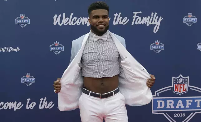 FILE - Ohio State's Ezekiel Elliott poses for photos upon arriving for the first round of the NFL football draft April 28, 2016, in Chicago. Elliott stunned on the red carpet when he unbuttoned his suit jacket to reveal his bare, toned abs, raising the bar for draft night fashion surprises. (AP Photo/Nam Y. Huh, File)