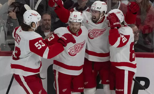 Detroit Red Wings' Dylan Larkin (71) celebrates his goal over Montreal Canadiens with teammates Moritz Seider (53), Alex DeBrincat (93) and Patrick Kane (88) during the first period of an NHL hockey game in Montreal on Tuesday, April 8, 2025. (Christinne Muschi/The Canadian Press via AP)