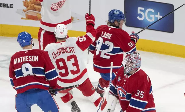 Detroit Red Wings' Dylan Larkin (71) celebrates his goal over Montreal Canadiens goaltender Sam Montembeault (35) during the first period of an NHL hockey game in Montreal on Tuesday, April 8, 2025. (Christinne Muschi/The Canadian Press via AP)
